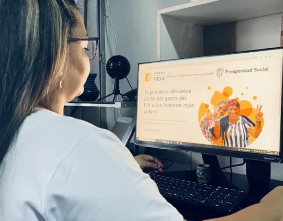 Imagen de mujer en un computador mirando la pagina oficial.