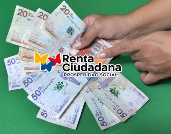 Imagen de dinero colombiano y manos sosteniéndolo.