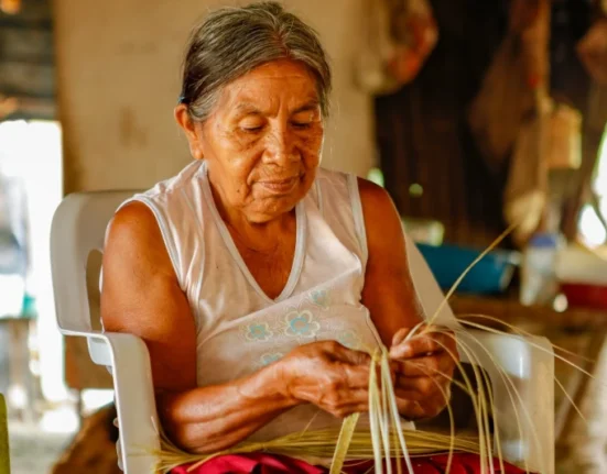 Imagen de mujer nativa tejiendo.